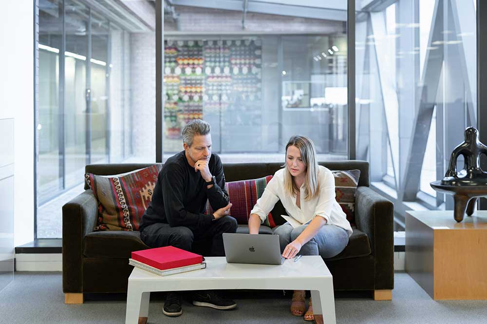 Clients reviewing paperwork together on a laptop